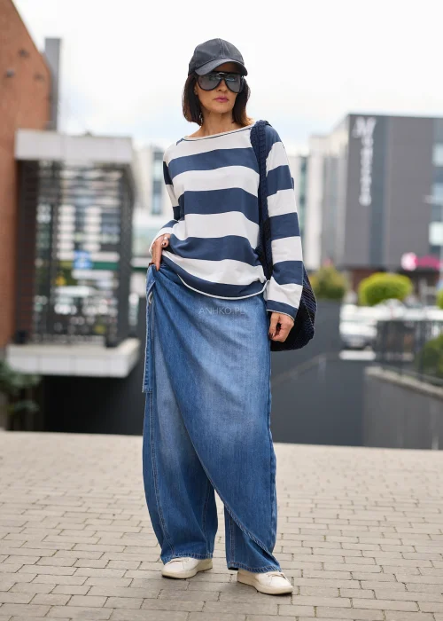Jeansy damskie wide leg w niebieskim denimie, z asymetrycznym kopertowym przodem, wysokim stanem i szerokimi nogawkami.