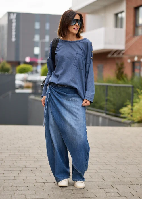 Jeansy damskie wide leg w niebieskim denimie, z asymetrycznym kopertowym przodem, wysokim stanem i szerokimi nogawkami.