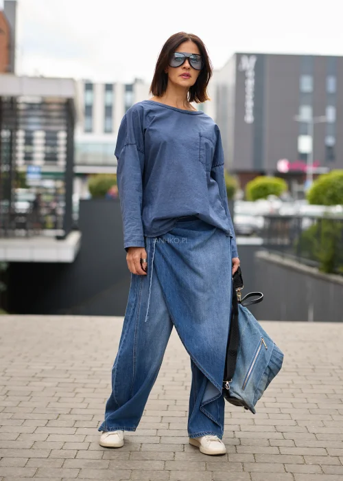 Jeansy damskie wide leg w niebieskim denimie, z asymetrycznym kopertowym przodem, wysokim stanem i szerokimi nogawkami.