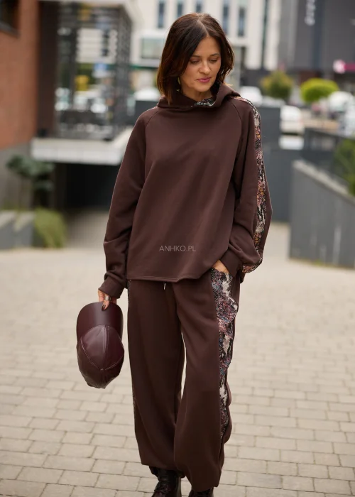 Bluza damska oversize w czekoladowym brązie z kapturem i kontrastowymi, wielokolorowymi wstawkami o gobelinowej strukturze na rękawach.