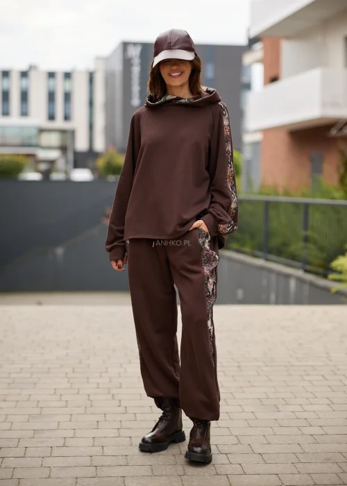 Bluza damska oversize w czekoladowym brązie z kapturem i kontrastowymi, wielokolorowymi wstawkami o gobelinowej strukturze na rękawach.