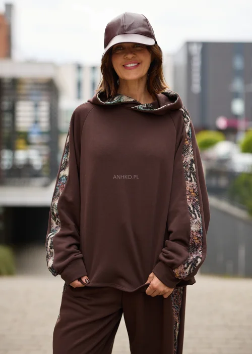 Bluza damska oversize w czekoladowym brązie z kapturem i kontrastowymi, wielokolorowymi wstawkami o gobelinowej strukturze na rękawach.
