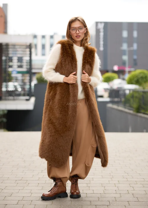 Puszysty sweter damski w kremowym kolorze, o luźnym fasonie, z okrągłym dekoltem, długimi rękawami i miękką, włochatą fakturą dzianiny.
