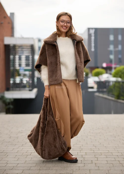 Puszysty sweter damski w kremowym kolorze, o luźnym fasonie, z okrągłym dekoltem, długimi rękawami i miękką, włochatą fakturą dzianiny.