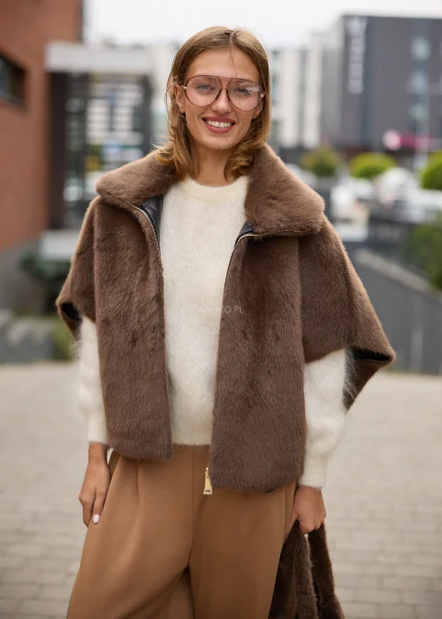 Dwustronna peleryna damska oversize w brązowym kolorze, łącząca miękkie sztuczne futro z kontrastową gładką stroną imitującą skórę, z szerokim kołnierzem i zapięciem na suwak.