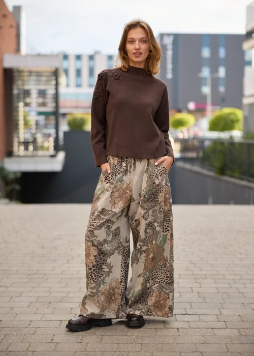 Spodnie damskie z szerokimi nogawkami w beżowej kolorystyce, z patchworkowym wzorem łączącym motywy kwiatowe, paisley i animal print oraz regulacją w pasie.