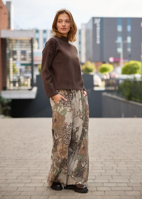 Spodnie damskie z szerokimi nogawkami w beżowej kolorystyce, z patchworkowym wzorem łączącym motywy kwiatowe, paisley i animal print oraz regulacją w pasie.