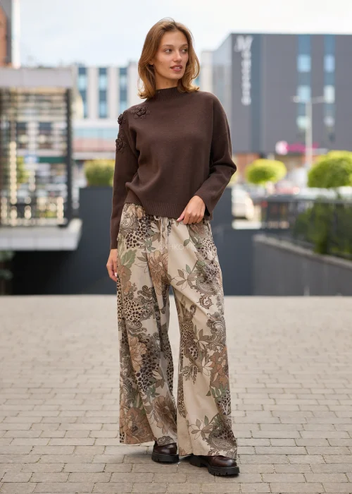 Spodnie damskie z szerokimi nogawkami w beżowej kolorystyce, z patchworkowym wzorem łączącym motywy kwiatowe, paisley i animal print oraz regulacją w pasie.