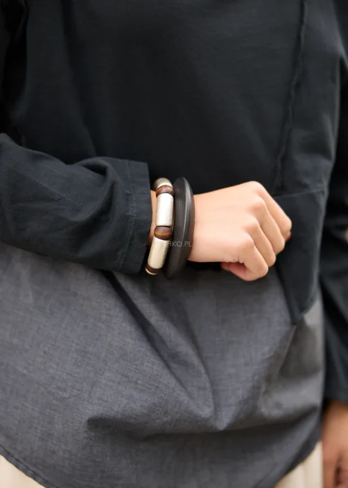 Drewniany komplet bransoletek Odelia Duo w czarno-brązowo-srebrnej kolorystyce, z szeroką czarną obręczą oraz dużymi koralikami o postarzanym wykończeniu.