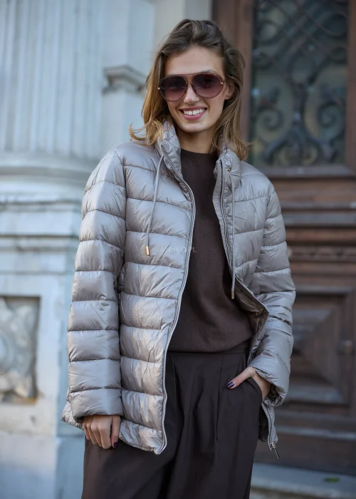 Taupe kurtka damska 2w1 o fasonie oversize, łącząca miękkie futrzane wykończenie z pikowaną warstwą, dużym kapturem, wysokim kołnierzem i zapięciem na suwak.