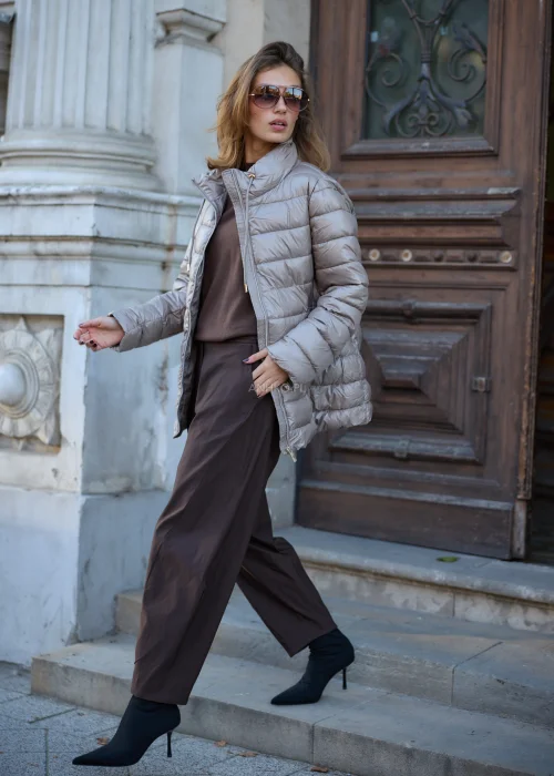 Taupe kurtka damska 2w1 o fasonie oversize, łącząca miękkie futrzane wykończenie z pikowaną warstwą, dużym kapturem, wysokim kołnierzem i zapięciem na suwak.