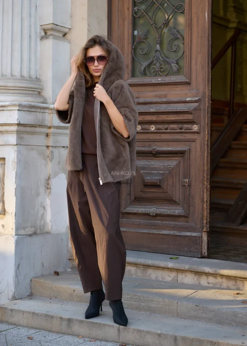 Taupe kurtka damska 2w1 o fasonie oversize, łącząca miękkie futrzane wykończenie z pikowaną warstwą, dużym kapturem, wysokim kołnierzem i zapięciem na suwak.