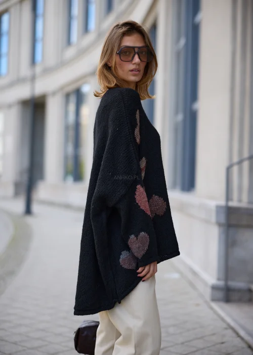 Sweter damski oversize z miękkiej, lekko puszystej dzianiny w kolorze czarnym, ozdobiony nieregularnie rozmieszczonymi, dzianinowymi sercami w odcieniach różu, bordo, beżu i szarości