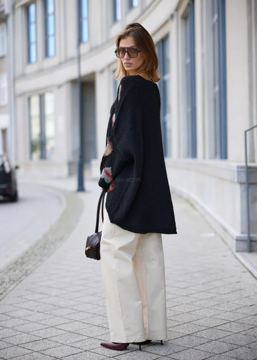 Sweter damski oversize z miękkiej, lekko puszystej dzianiny w kolorze czarnym, ozdobiony nieregularnie rozmieszczonymi, dzianinowymi sercami w odcieniach różu, bordo, beżu i szarości