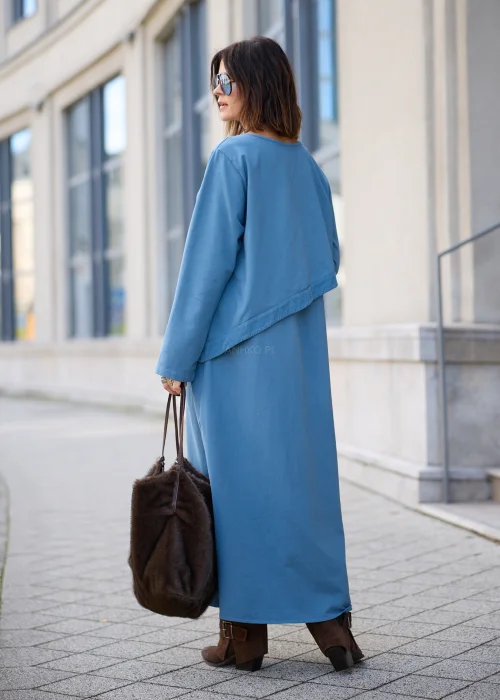 Sukienka damska maxi w kolorze przygaszonego błękitu, o mocno oversize’owym fasonie, z długimi rękawami, okrągłym dekoltem, asymetryczną warstwą materiału, pionowym rzędem guzików i dużą naszywaną kieszenią.
