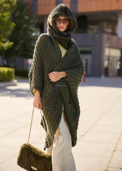 Oliwkowozielony kardigan damski maxi oversize z grubej dzianiny o wyrazistym splocie, z szerokimi rękawami, kieszeniami i asymetrycznym dołem.