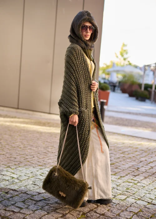 Oliwkowozielony kardigan damski maxi oversize z grubej dzianiny o wyrazistym splocie, z szerokimi rękawami, kieszeniami i asymetrycznym dołem.