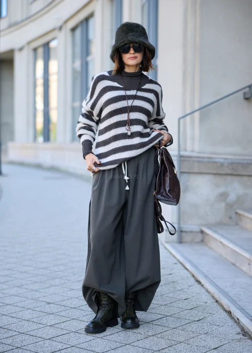 Sweter damski oversize z miękkiej, lekko puszystej dzianiny w szerokie, poziome pasy w kolorze kremowym i ciemnografitowym, o luźnym fasonie z obniżoną linią ramion, szerokim dekoltem w łódkę