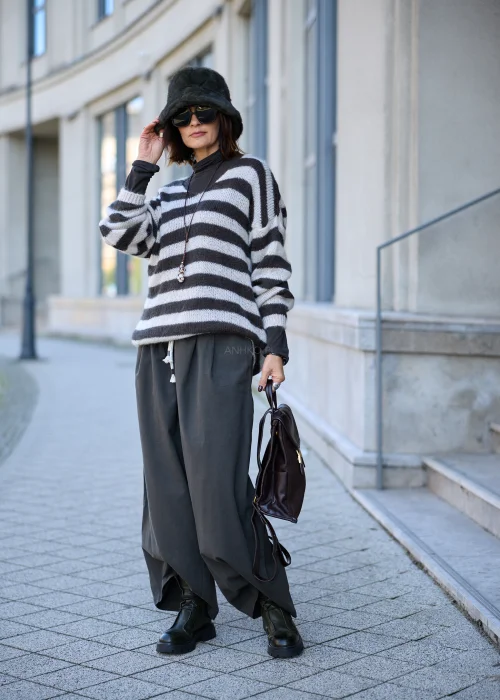Sweter damski oversize z miękkiej, lekko puszystej dzianiny w szerokie, poziome pasy w kolorze kremowym i ciemnografitowym, o luźnym fasonie z obniżoną linią ramion, szerokim dekoltem w łódkę