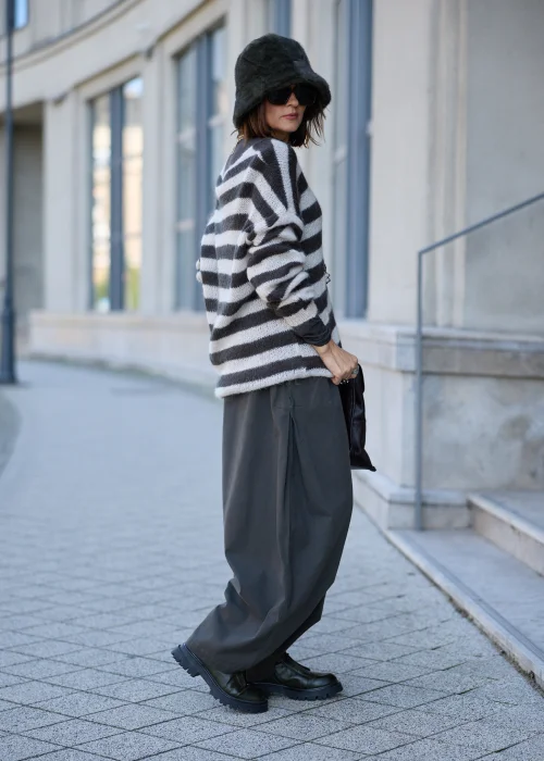 Sweter damski oversize z miękkiej, lekko puszystej dzianiny w szerokie, poziome pasy w kolorze kremowym i ciemnografitowym, o luźnym fasonie z obniżoną linią ramion, szerokim dekoltem w łódkę