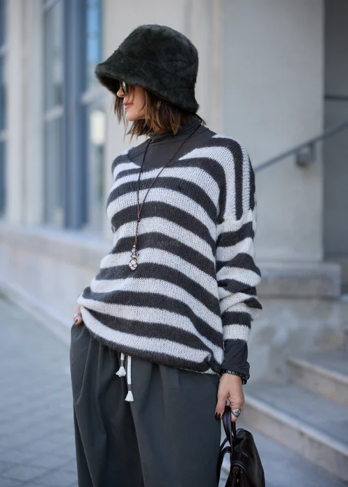 Sweter damski oversize z miękkiej, lekko puszystej dzianiny w szerokie, poziome pasy w kolorze kremowym i ciemnografitowym, o luźnym fasonie z obniżoną linią ramion, szerokim dekoltem w łódkę