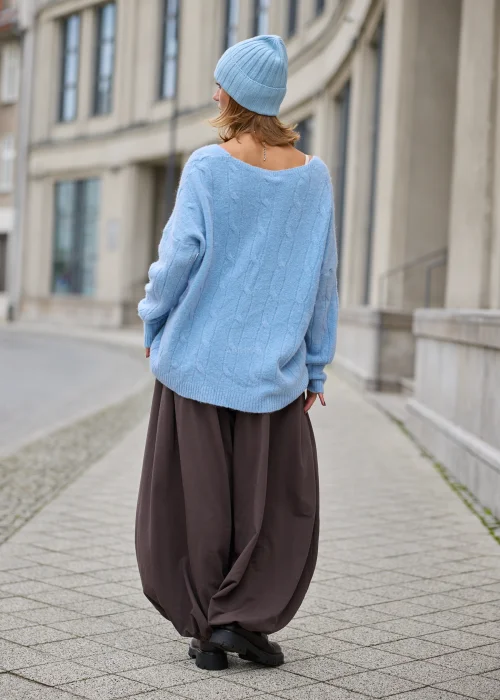Sweter damski oversize z miękkiej, puszystej dzianiny w kolorze jasnego błękitu, z szerokim dekoltem w serek, obniżoną linią ramion, długimi rękawami zakończonymi szerokimi prążkowanymi mankietami