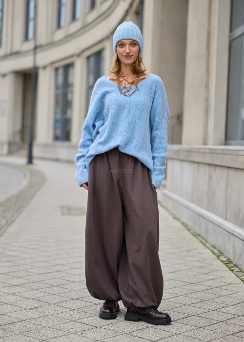 Sweter damski oversize z miękkiej, puszystej dzianiny w kolorze jasnego błękitu, z szerokim dekoltem w serek, obniżoną linią ramion, długimi rękawami zakończonymi szerokimi prążkowanymi mankietami