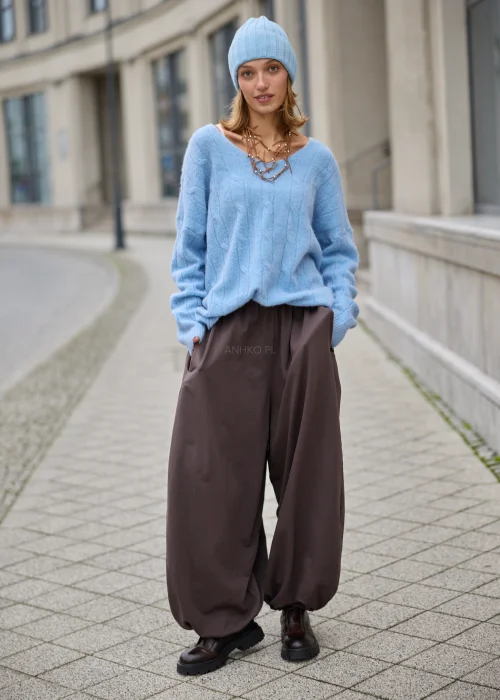 Sweter damski oversize z miękkiej, puszystej dzianiny w kolorze jasnego błękitu, z szerokim dekoltem w serek, obniżoną linią ramion, długimi rękawami zakończonymi szerokimi prążkowanymi mankietami