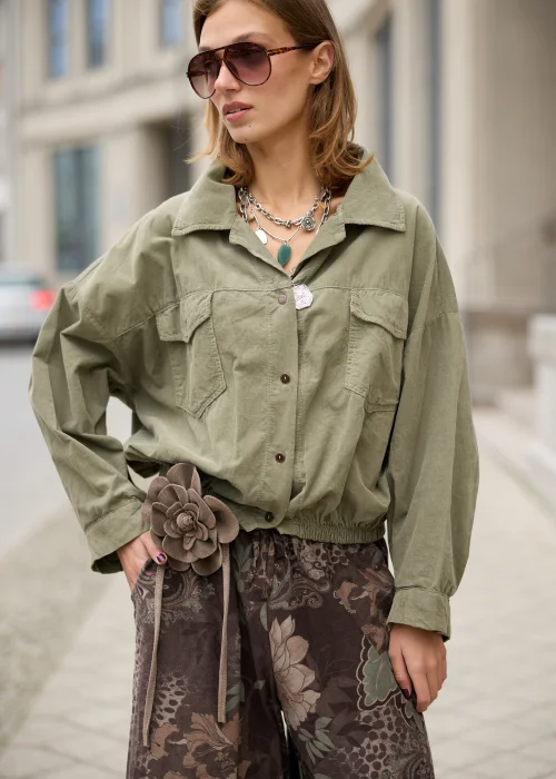 Koszula damska oversize w kolorze khaki, z dwiema kieszeniami na piersi, szerokimi rękawami i elastycznym dołem.