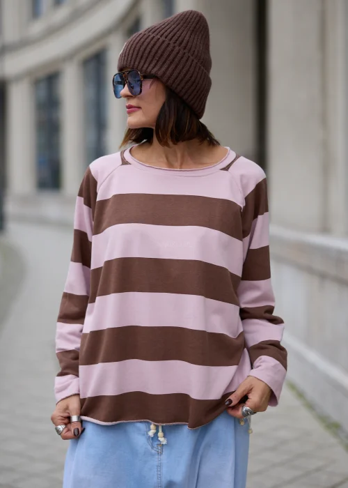 Bluza damska oversize w szerokie poziome pasy w kolorze pudrowego różu i czekoladowego brązu, z okrągłym dekoltem, długimi rękawami oraz surowo wykończonym dołem i mankietami.