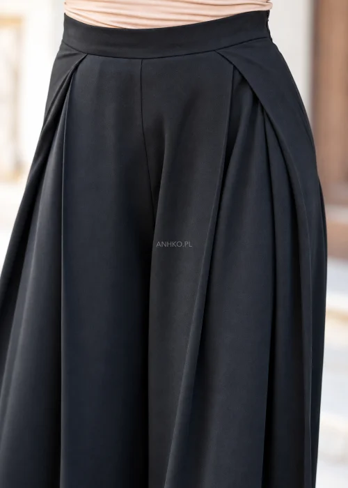 Eleganckie spodnie damskie w kolorze czarnym, z wysokim stanem, szerokimi nogawkami typu palazzo, zakładkami przy talii i asymetrycznym, kopertowym wykończeniem pasa.