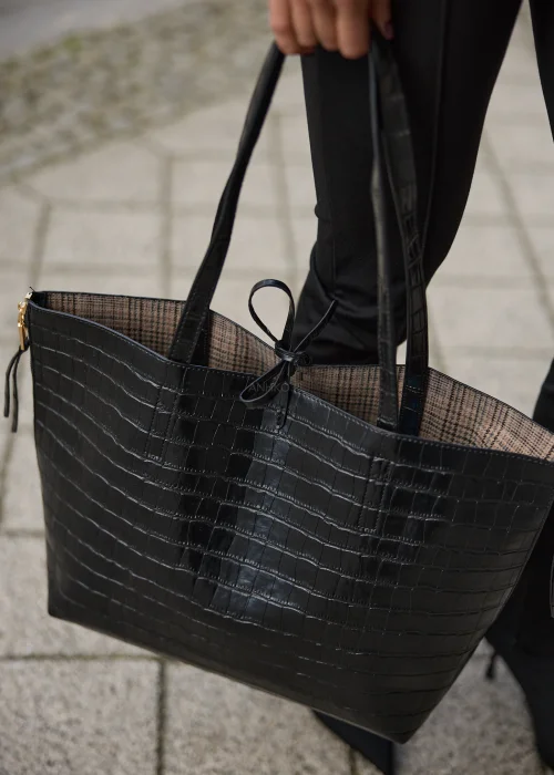 Duża torebka shopper damska w czarnym kolorze z tłoczeniem imitującym skórę krokodyla, wyposażona w dopasowaną kosmetyczkę i złote detale.