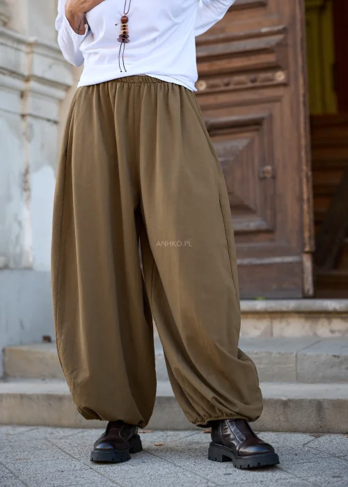 Spodnie damskie balloon w kolorze khaki, mocno oversize, z szerokimi, obszernymi nogawkami zakończonymi gumką, elastycznym pasem i swobodnym fasonem.