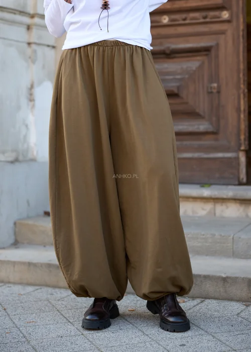 Spodnie damskie balloon w kolorze khaki, mocno oversize, z szerokimi, obszernymi nogawkami zakończonymi gumką, elastycznym pasem i swobodnym fasonem.