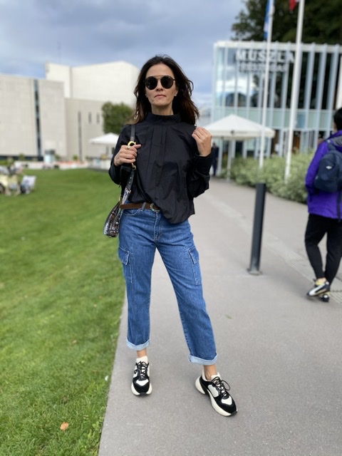 Beżowa bluzka damska oversize z wysoką stójką i szerokimi rękawami, minimalistyczny fason zestawiony z jasnymi jeansami w casualowej stylizacji.