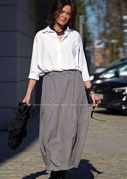 Damska spódnica bombka midi w czarno-białą szachownicę z kieszeniami, zestawiona z białą koszulą. Model o objętościowym kroju i elastycznym pasie.