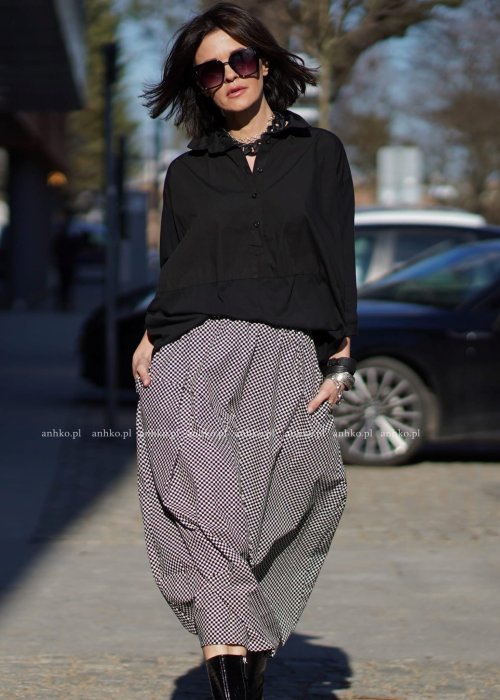 Damska spódnica bombka midi w czarno-białą szachownicę z kieszeniami, zestawiona z białą koszulą. Model o objętościowym kroju i elastycznym pasie.