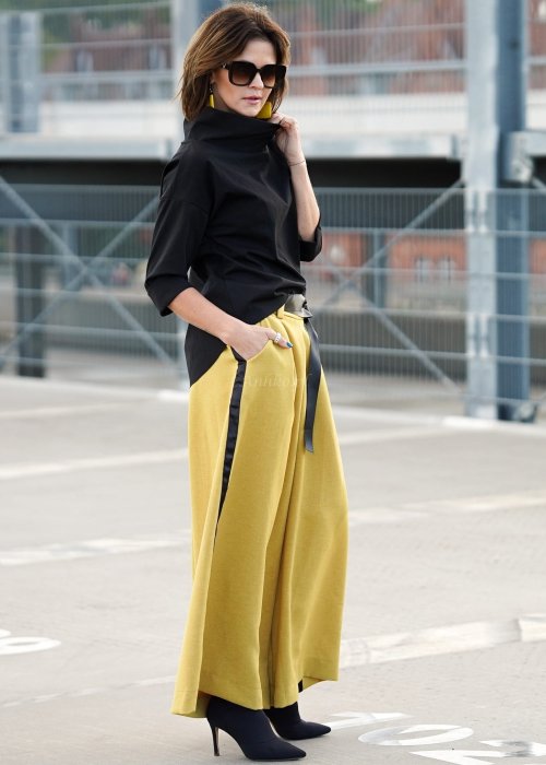 Czarna bluzka oversize z półgolfem i rękawem 3/4, stylizowana z szerokimi spodniami w kontrastowym kolorze w miejskim looku.