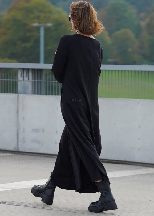 Czarny kombinezon damski z długim rękawem i bardzo szeroką nogawką, luźny fason w stylizacji z ciężkimi botkami na platformie.