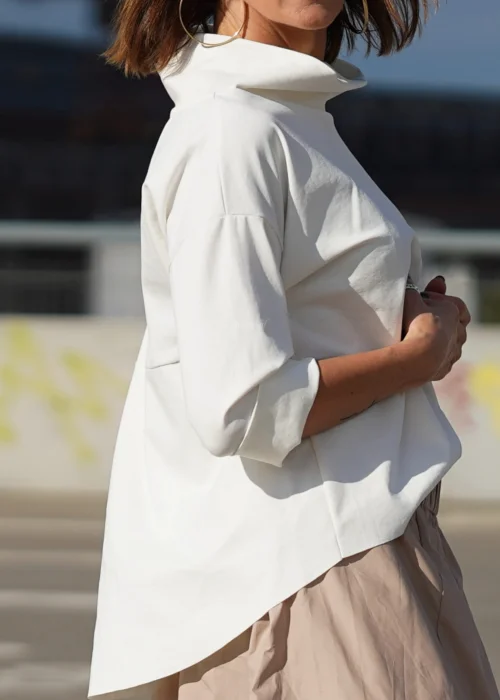 Biała bluzka oversize z półgolfem i rękawami 3/4. Minimalistyczny fason z wydłużonym tyłem do eleganckich i codziennych stylizacji.