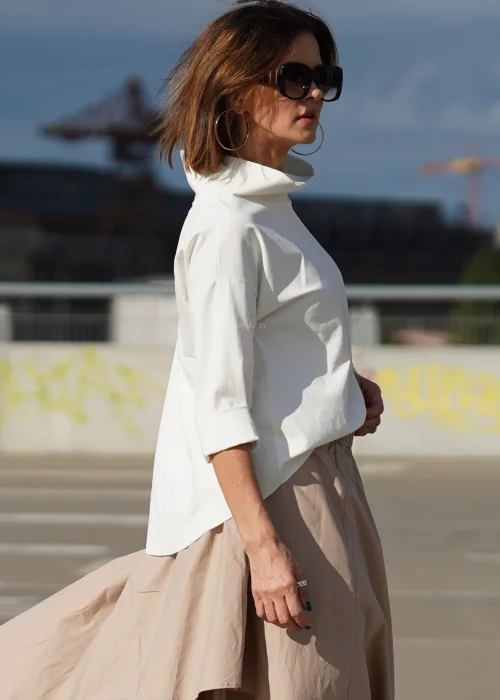 Biała bluzka oversize z półgolfem i rękawami 3/4. Minimalistyczny fason z wydłużonym tyłem do eleganckich i codziennych stylizacji.