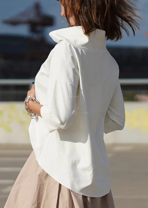 Biała bluzka oversize z półgolfem i rękawami 3/4. Minimalistyczny fason z wydłużonym tyłem do eleganckich i codziennych stylizacji.