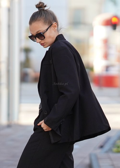 Czarna marynarka damska oversize o klasycznym kroju, stylizowana z eleganckimi spodniami i okularami przeciwsłonecznymi w miejskim looku.