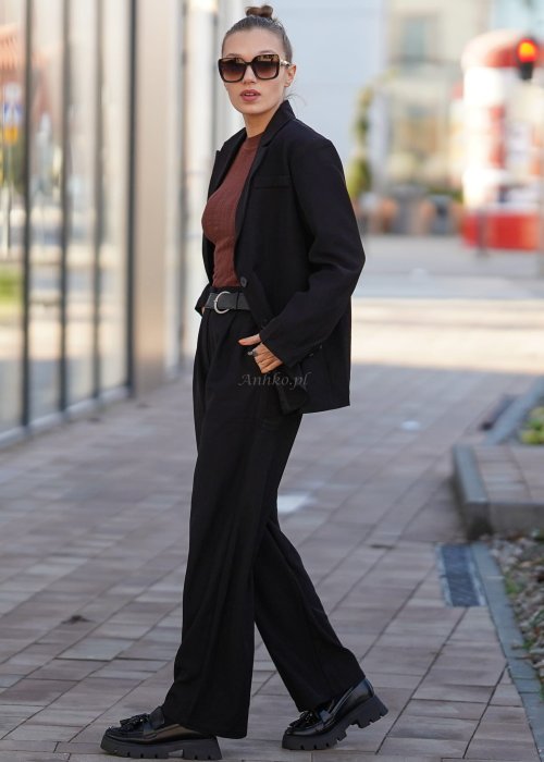 Czarna marynarka damska oversize o klasycznym kroju, stylizowana z eleganckimi spodniami i okularami przeciwsłonecznymi w miejskim looku.