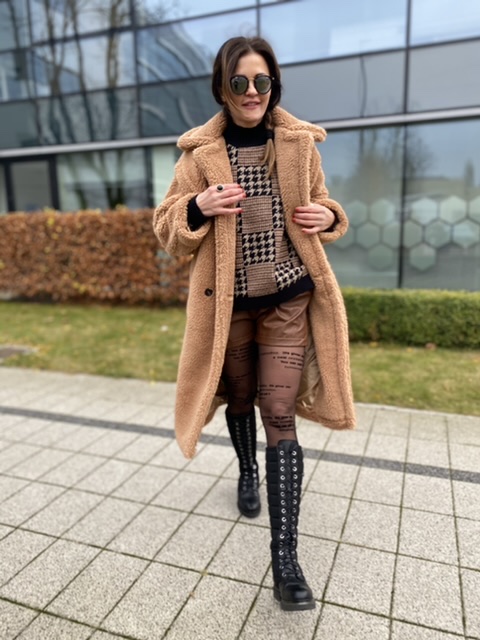 Czarne spodenki damskie z eco-skóry o luźnym kroju z wiązaniem w pasie, stylizacja miejska z marynarką i wysokimi botkami.