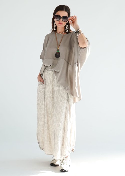 Bluzka oversize w kolorze taupe z szerokim rękawem i luźnym krojem. Stylizacja z jasną spódnicą i biżuterią w stylu boho.