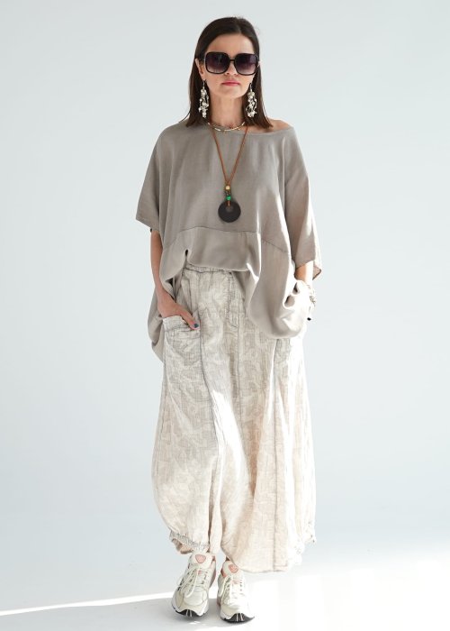 Bluzka oversize w kolorze taupe z szerokim rękawem i luźnym krojem. Stylizacja z jasną spódnicą i biżuterią w stylu boho.