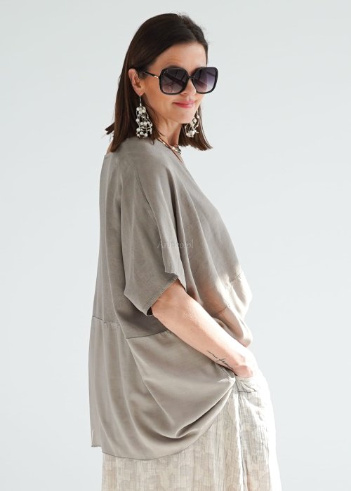 Bluzka oversize w kolorze taupe z szerokim rękawem i luźnym krojem. Stylizacja z jasną spódnicą i biżuterią w stylu boho.