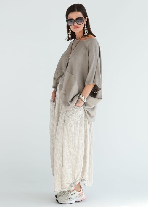 Bluzka oversize w kolorze taupe z szerokim rękawem i luźnym krojem. Stylizacja z jasną spódnicą i biżuterią w stylu boho.