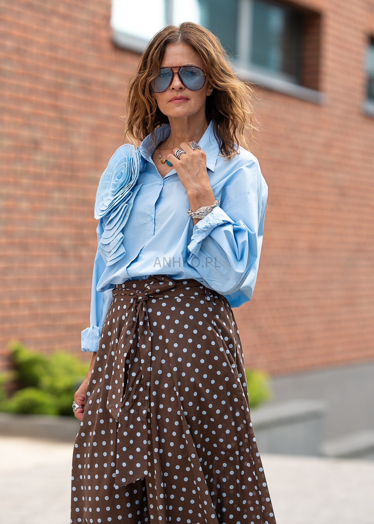 Niebieska koszula damska oversize z długim rękawem i plisowaną aplikacją kwiatową na ramieniu w stylu eleganckim